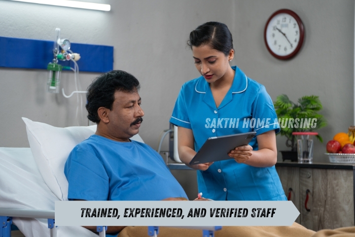 Trained nurse assisting a male patient with medical records at home,Sakthi Home Nursing’s verified and experienced staff